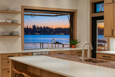 Minimalist l-shaped open concept kitchen photo in Other with an undermount sink, recessed-panel cabinets, brown cabinets, white backsplash, ceramic backsplash, stainless steel appliances and an island