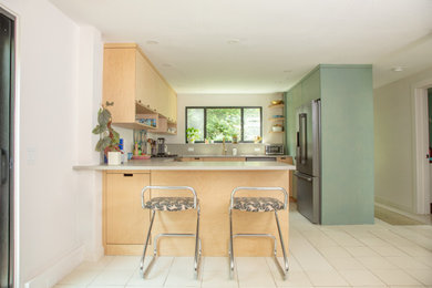 Mid-sized 1960s u-shaped ceramic tile and white floor eat-in kitchen photo in Boston with an undermount sink, flat-panel cabinets, green cabinets, concrete countertops, multicolored backsplash, cement tile backsplash, stainless steel appliances, a peninsula and white countertops