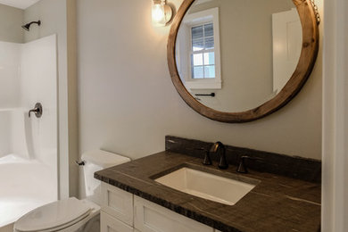 Example of a mid-sized transitional kids' dark wood floor and brown floor bathroom design in Other with recessed-panel cabinets, white cabinets, beige walls, an undermount sink and granite countertops