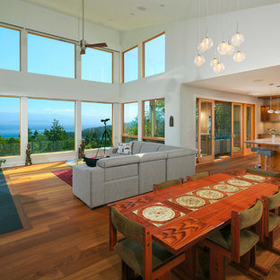 バンクーバーの中サイズのモダンスタイルのLDKの画像 (白い壁、無垢フローリング、標準型暖炉、コンクリートの暖炉まわり)