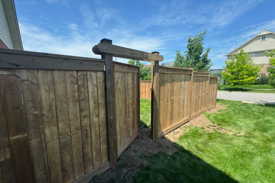 Photo of a large modern privacy backyard wood fence landscaping in Toronto.