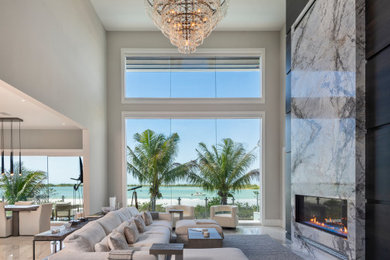 Example of a large transitional formal and open concept ceramic tile, gray floor, vaulted ceiling and wood wall living room design in Miami with a stone fireplace