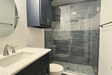 Mid-sized blue tile porcelain tile, blue floor and single-sink bathroom photo in Dallas with blue cabinets, quartzite countertops, white countertops and a niche
