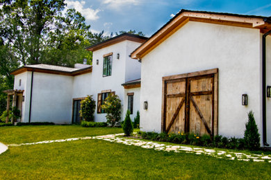 Example of a huge tuscan white one-story stucco house exterior design in St Louis with a tile roof and a hip roof