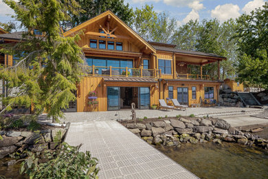 Example of a large mountain style brown three-story mixed siding and clapboard exterior home design in Seattle with a mixed material roof and a gray roof