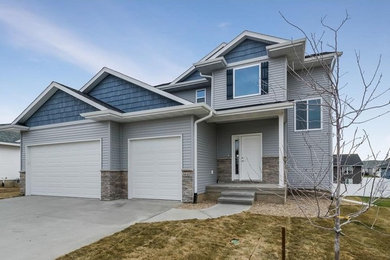 Mid-sized elegant blue two-story wood exterior home photo in Cedar Rapids with a shingle roof