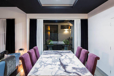 Photo of a contemporary dining room in Melbourne with white walls, concrete floors and grey floor.