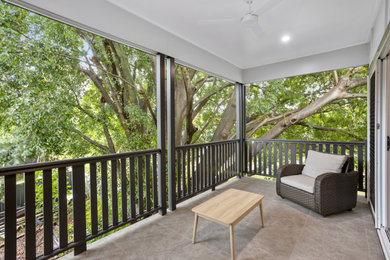 Photo of a mid-sized country balcony in Brisbane with with privacy feature and wood railing.
