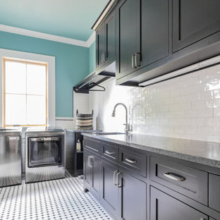 ヒューストンの大きいカントリー風おしゃれな洗濯室 (アンダーカウンターシンク、シェーカースタイル扉のキャビネット、黒いキャビネット、御影石カウンター、青い壁、セラミックタイルの床、左右配置の洗濯機・乾燥機、マルチカラーの床、黒いキッチンカウンター) の写真