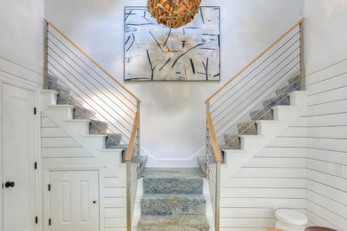 Mid-sized beach style carpeted u-shaped staircase in New York with carpet risers and cable railing.