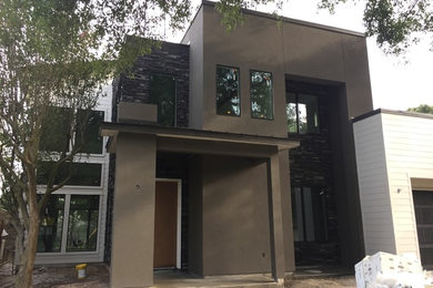 Mittelgroßes, Zweistöckiges Modernes Einfamilienhaus mit Mix-Fassade, brauner Fassadenfarbe, Flachdach und Blechdach in Houston