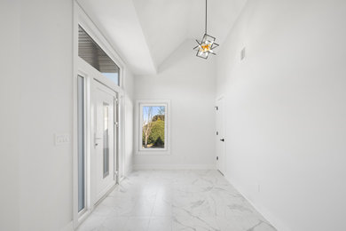 Inspiration for a large marble floor, white floor, vaulted ceiling and wood wall entryway remodel in New York with white walls and a medium wood front door