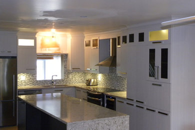 Inspiration for a mid-sized transitional l-shaped kitchen remodel in Montreal with flat-panel cabinets and an island