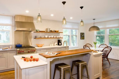 Inspiration for a mid-sized transitional l-shaped medium tone wood floor eat-in kitchen remodel in Boston with a farmhouse sink, beaded inset cabinets, gray cabinets, marble countertops, white backsplash, subway tile backsplash, paneled appliances and an island