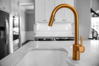 Large minimalist galley medium tone wood floor and brown floor eat-in kitchen photo in Other with a single-bowl sink, shaker cabinets, white cabinets, quartz countertops, stainless steel appliances, an island and white countertops