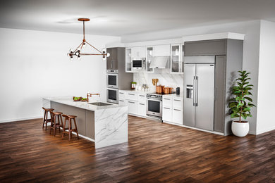 Design ideas for a large contemporary galley open plan kitchen in New York with an undermount sink, flat-panel cabinets, white cabinets, quartzite benchtops, multi-coloured splashback, stone slab splashback, stainless steel appliances, dark hardwood floors, with island and brown floor.