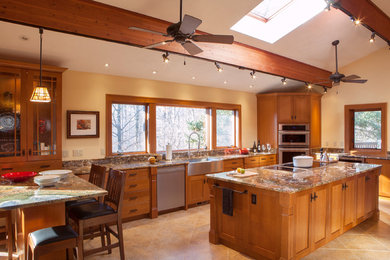 Example of a large classic u-shaped ceramic tile eat-in kitchen design in Cleveland with a farmhouse sink, shaker cabinets, medium tone wood cabinets, granite countertops, beige backsplash, stone slab backsplash, stainless steel appliances and an island