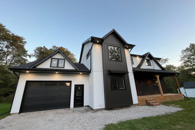 Inspiration for a mid-sized farmhouse white two-story vinyl and board and batten exterior home remodel in Toronto with a shingle roof and a black roof