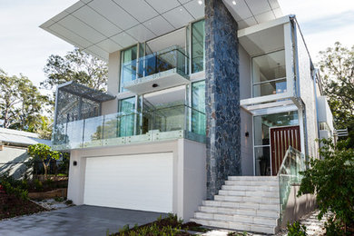This is an example of a contemporary three-storey white exterior in Brisbane with a flat roof.