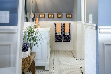 Inspiration for a mid-sized transitional master white tile and ceramic tile ceramic tile and white floor alcove shower remodel in Seattle with raised-panel cabinets, white cabinets, a one-piece toilet, blue walls, an undermount sink, marble countertops and a hinged shower door