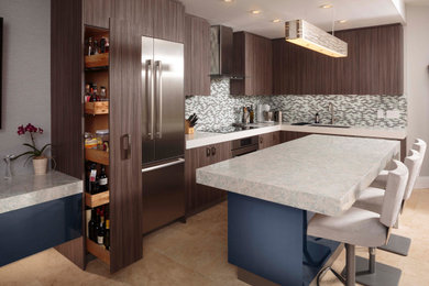 Inspiration for a contemporary l-shaped kitchen in Miami with an undermount sink, flat-panel cabinets, dark wood cabinets, multi-coloured splashback, mosaic tile splashback, stainless steel appliances, with island, beige floor and white benchtop.