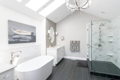 Example of a large transitional master white tile porcelain tile and black floor bathroom design in Philadelphia with recessed-panel cabinets, white cabinets, gray walls, an undermount sink, quartz countertops, a hinged shower door and white countertops