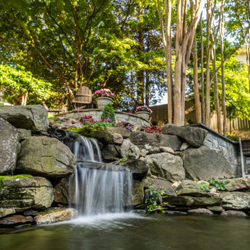 Natural Stone Waterfall Beneath a Shaded Garden Terrace