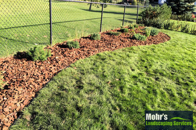 Inspiration for a mid-sized contemporary full sun backyard mulch landscaping in Edmonton.