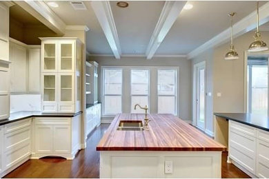 Example of a large classic l-shaped medium tone wood floor open concept kitchen design in Austin with an undermount sink, shaker cabinets, white cabinets, wood countertops, white backsplash, stone slab backsplash, stainless steel appliances and an island