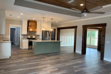 Large arts and crafts l-shaped vinyl floor, multicolored floor and coffered ceiling eat-in kitchen photo in Other with a farmhouse sink, shaker cabinets, green cabinets, marble countertops, multicolored backsplash, brick backsplash, stainless steel appliances, an island and multicolored countertops