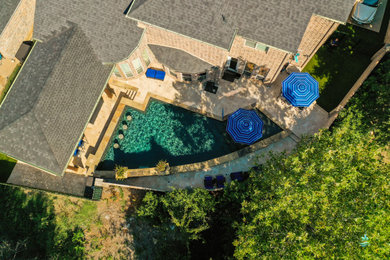 Example of a huge mountain style backyard stone and custom-shaped privacy pool design in Dallas