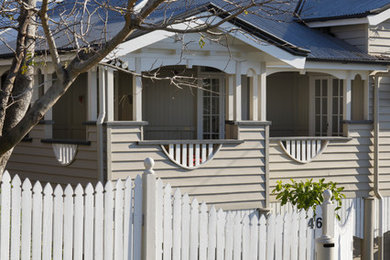 Design ideas for a mid-sized traditional two-storey exterior in Brisbane with wood siding and a hip roof.