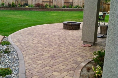 This is an example of a mid-sized traditional full sun backyard stone landscaping in Las Vegas with a fire pit for summer.