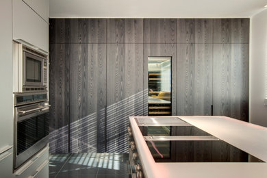 Foto di una grande cucina minimal con ante a filo, ante in legno bruno, top in superficie solida, pavimento in gres porcellanato e top bianco