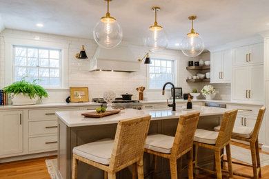 Transitional eat-in kitchen photo in Boston with white backsplash, subway tile backsplash, stainless steel appliances and an island