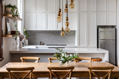 Inspiration for a transitional u-shaped eat-in kitchen in Perth with shaker cabinets, white cabinets, grey splashback, stainless steel appliances, a peninsula and white benchtop.