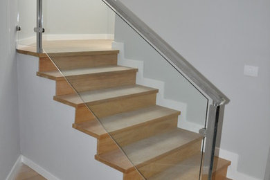 Example of a mid-sized trendy wooden l-shaped staircase design in Other with wooden risers