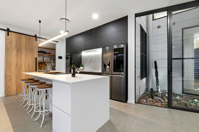 Inspiration for a modern galley open plan kitchen in Sunshine Coast with a double-bowl sink, black cabinets, quartz benchtops, white splashback, marble splashback, ceramic floors, with island, grey floor and white benchtop.