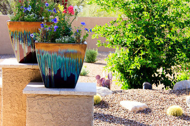 This is an example of a large mediterranean backyard partial sun xeriscape for summer in Phoenix with brick pavers.