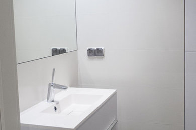 Inspiration for a small modern master black tile and ceramic tile ceramic tile doorless shower remodel in Other with a console sink, flat-panel cabinets, white cabinets, laminate countertops, a wall-mount toilet and white walls