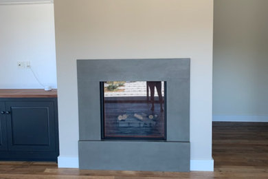 Photo of a medium sized enclosed games room in San Francisco with a concrete fireplace surround.