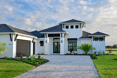 Inspiration for a mid-sized coastal white one-story stucco house exterior remodel in Other with a hip roof and a shingle roof