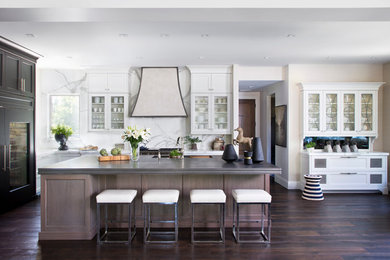 Inspiration for a transitional kitchen in Denver with glass-front cabinets, white cabinets, white splashback, panelled appliances, dark hardwood floors and with island.