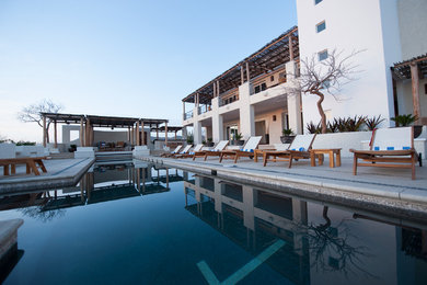 Example of a large minimalist backyard concrete and rectangular lap pool design in Other