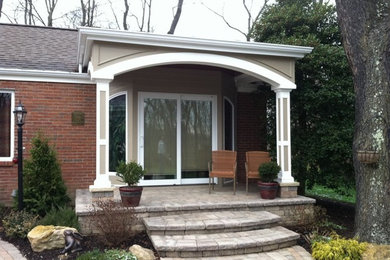 Patio - small traditional backyard brick patio idea in Other with a roof extension