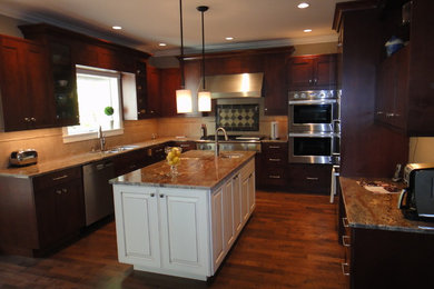 Inspiration for a large transitional u-shaped separate kitchen in Seattle with an undermount sink, shaker cabinets, dark wood cabinets, granite benchtops, beige splashback, ceramic splashback, stainless steel appliances, dark hardwood floors, with island and brown floor.