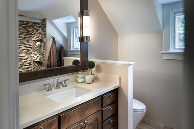 Design ideas for a mid-sized transitional bathroom in Other with recessed-panel cabinets, medium wood cabinets, a two-piece toilet, beige tile, brown tile, white tile, beige walls, ceramic floors, an undermount sink, engineered quartz benchtops, an alcove tub, a shower/bathtub combo and mosaic tile.