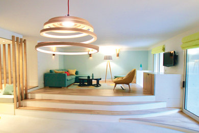 Exemple d'un grand salon scandinave ouvert avec un mur vert, parquet clair et un téléviseur fixé au mur.