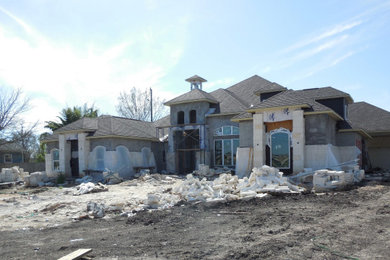 Mid-sized tuscan white one-story stone house exterior photo in Houston with a hip roof and a shingle roof