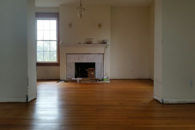 Living room - traditional medium tone wood floor and brown floor living room idea in St Louis with a standard fireplace and a stone fireplace